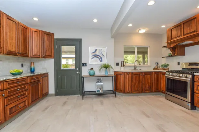 a kitchen with stainless steel appliances granite countertop a stove a sink and a refrigerator