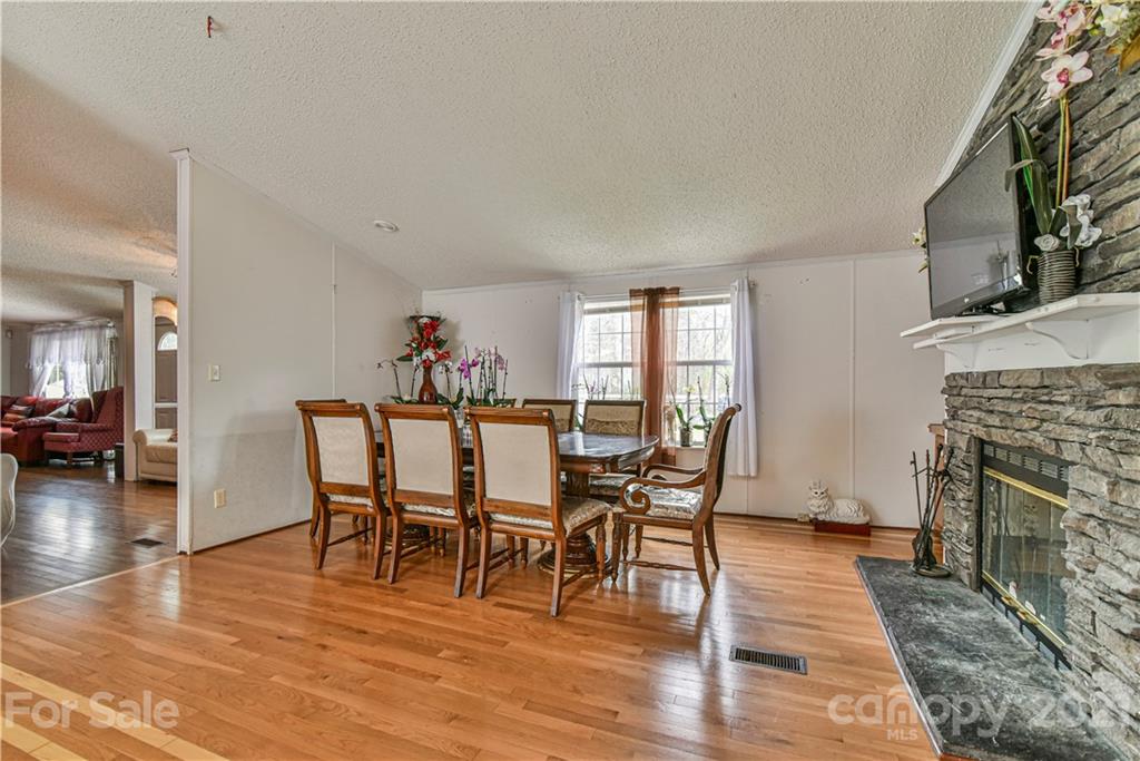 599 Pace Road Hendersonville, NC 28792 - Photo 12 of 24 a dining room with furniture wooden floor a fireplace and a chandelier