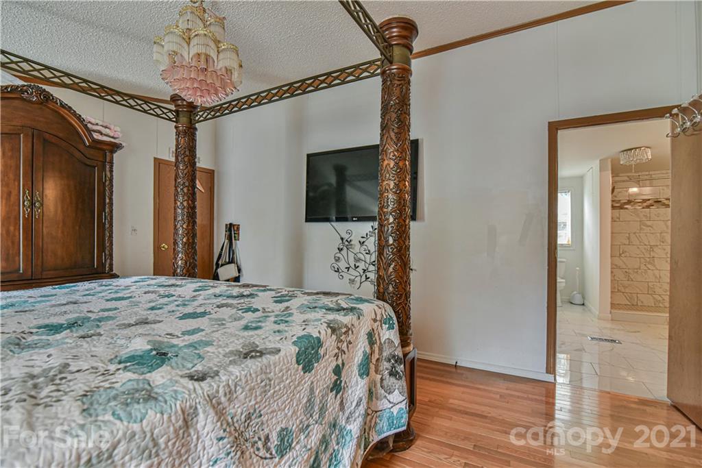 599 Pace Road Hendersonville, NC 28792 - Photo 14 of 24 a bedroom with a bed and a chandelier