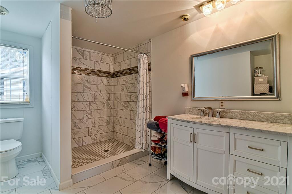 599 Pace Road Hendersonville, NC 28792 - Photo 15 of 24 a bathroom with a shower sink vanity and mirror