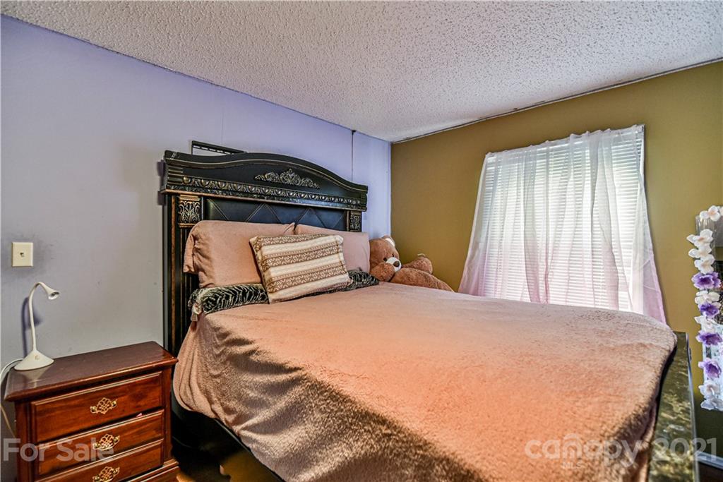 599 Pace Road Hendersonville, NC 28792 - Photo 19 of 24 a bedroom with a bed and wooden floor