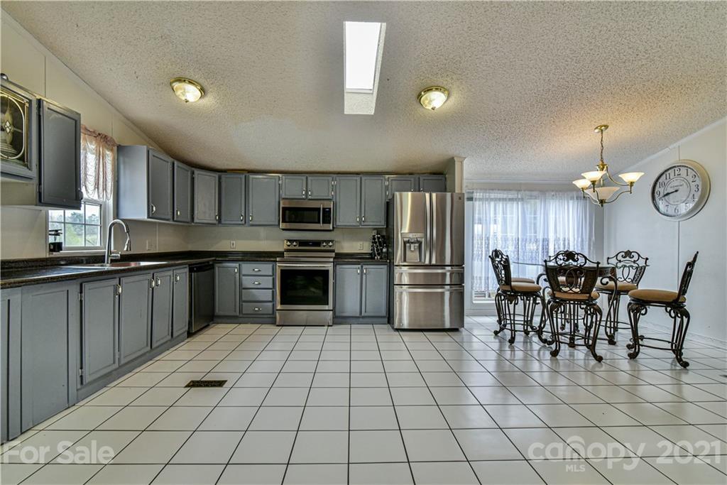 599 Pace Road Hendersonville, NC 28792 - Photo 4 of 24 a kitchen with stainless steel appliances a stove a sink cabinets and entryway