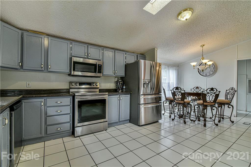 599 Pace Road Hendersonville, NC 28792 - Photo 6 of 24 a kitchen with stainless steel appliances a stove refrigerator sink and microwave