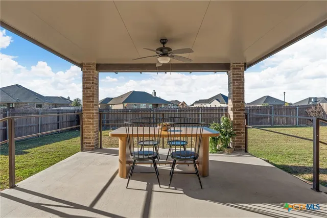 a view of a chairs and table in patio with a yard