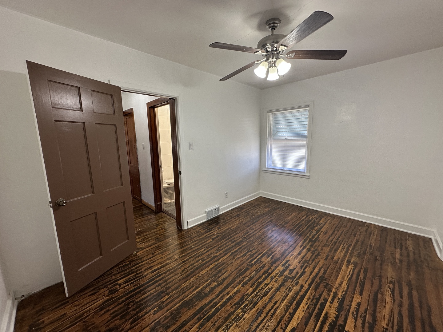 1202 East Jefferson Street Clinton, IL 61727 - Photo 11 of 19 a view of an empty room with wooden floor and a window