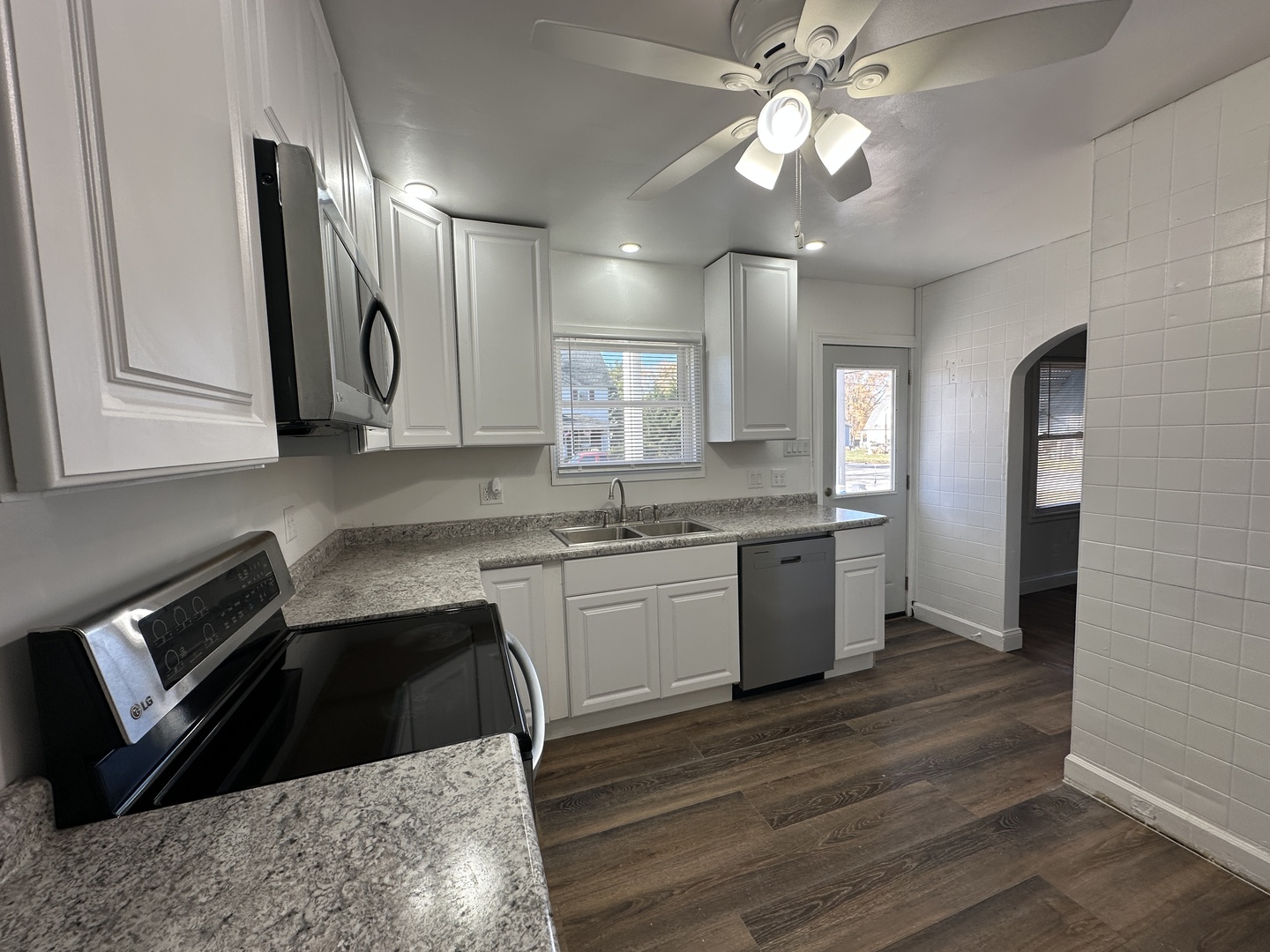 1202 East Jefferson Street Clinton, IL 61727 - Photo 5 of 19 a kitchen with granite countertop a stove a sink and a refrigerator