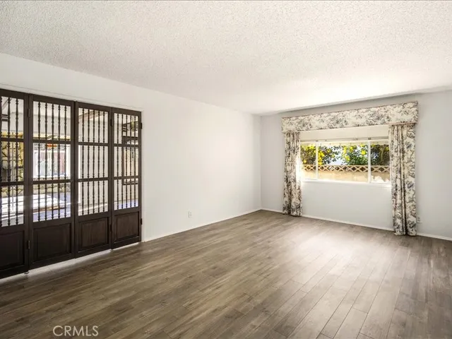 a view of an empty room with wooden floor