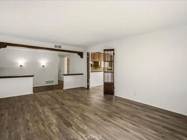 a view of a room with wooden floor and a refrigerator