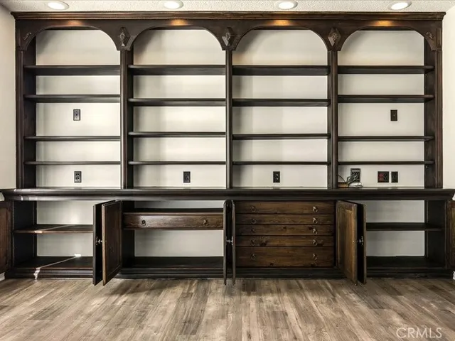 a view of a kitchen with stainless steel appliances wooden floor and living room view
