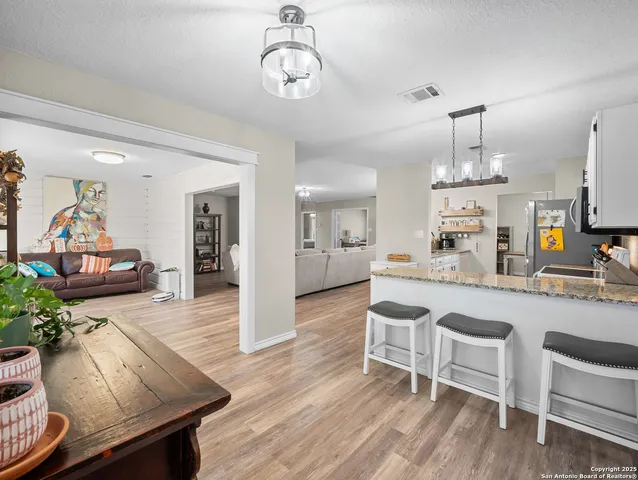 a living room with furniture kitchen view and a chandelier