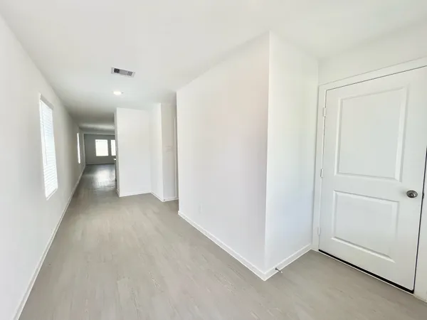 a view of a big room with wooden floor and windows