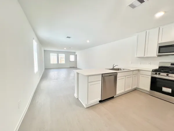 a kitchen with white cabinets and white appliances