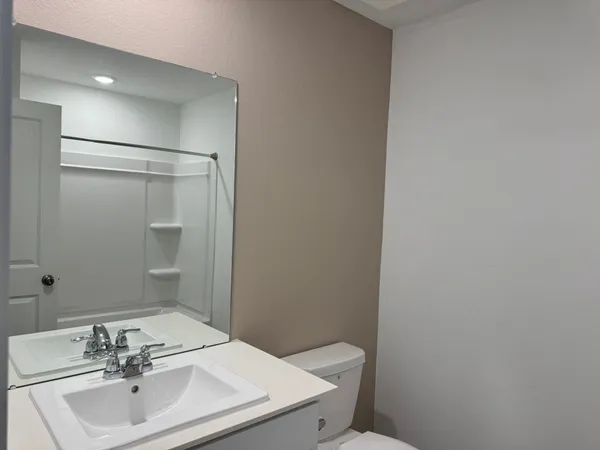 a bathroom with a sink a toilet and a mirror