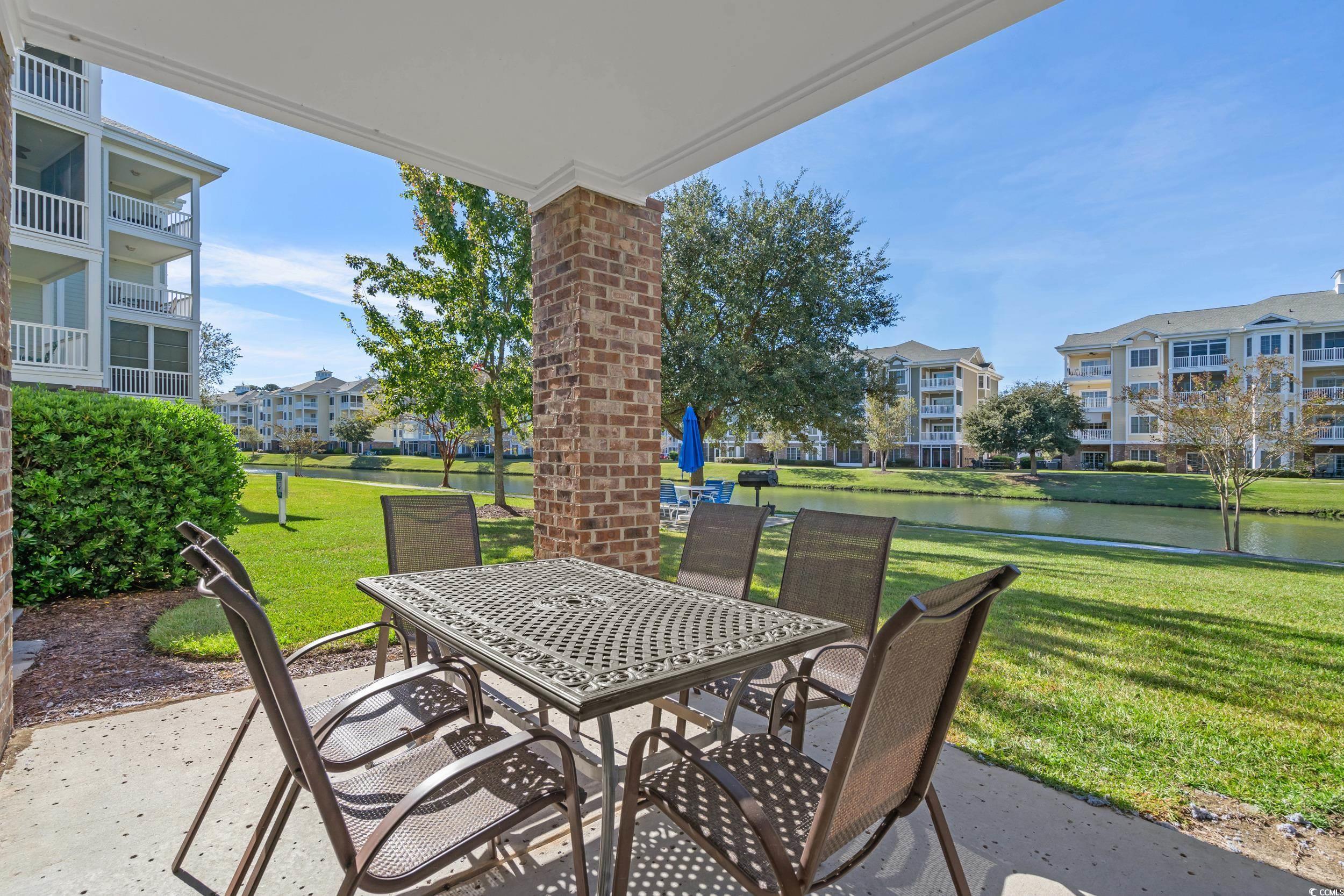4823 Magnolia Lake Drive, Unit 101 Myrtle Beach, SC 29577 - Photo 16 of 35 View of patio featuring a water view and outdoor dining space
