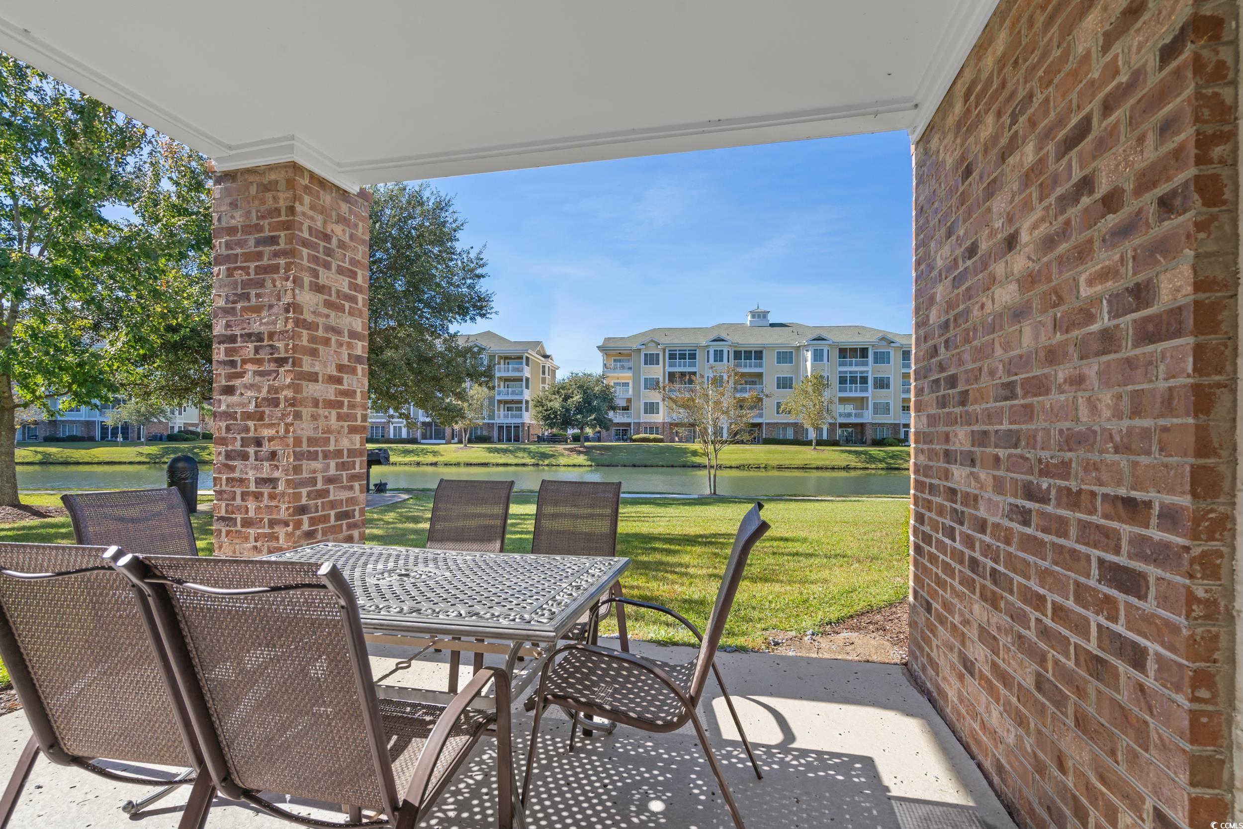 4823 Magnolia Lake Drive, Unit 101 Myrtle Beach, SC 29577 - Photo 17 of 35 View of patio / terrace featuring a water view and outdoor dining area