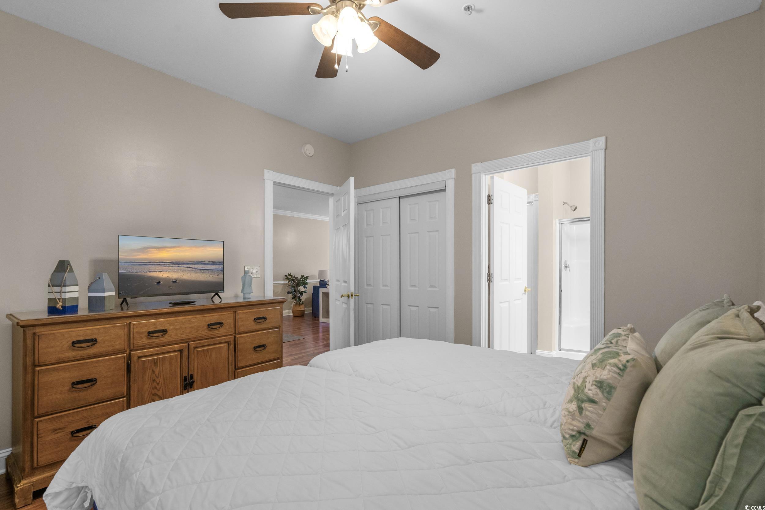 4823 Magnolia Lake Drive, Unit 101 Myrtle Beach, SC 29577 - Photo 21 of 35 Bedroom featuring ceiling fan, a closet, and wood finished floors