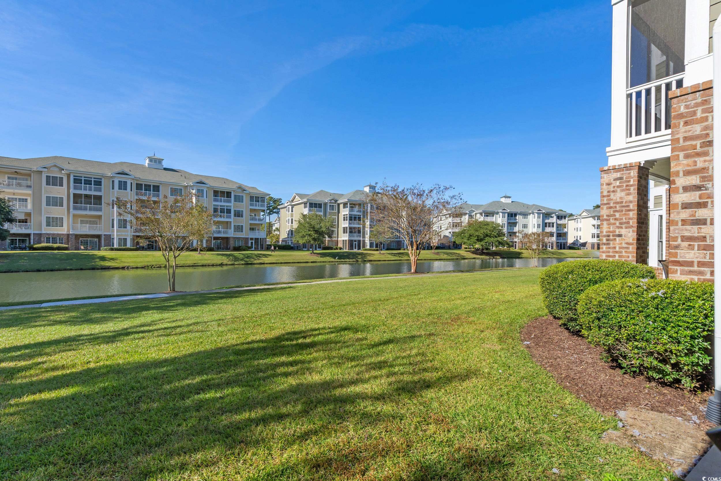4823 Magnolia Lake Drive, Unit 101 Myrtle Beach, SC 29577 - Photo 27 of 35 View of community featuring a water view, a lawn, and a balcony