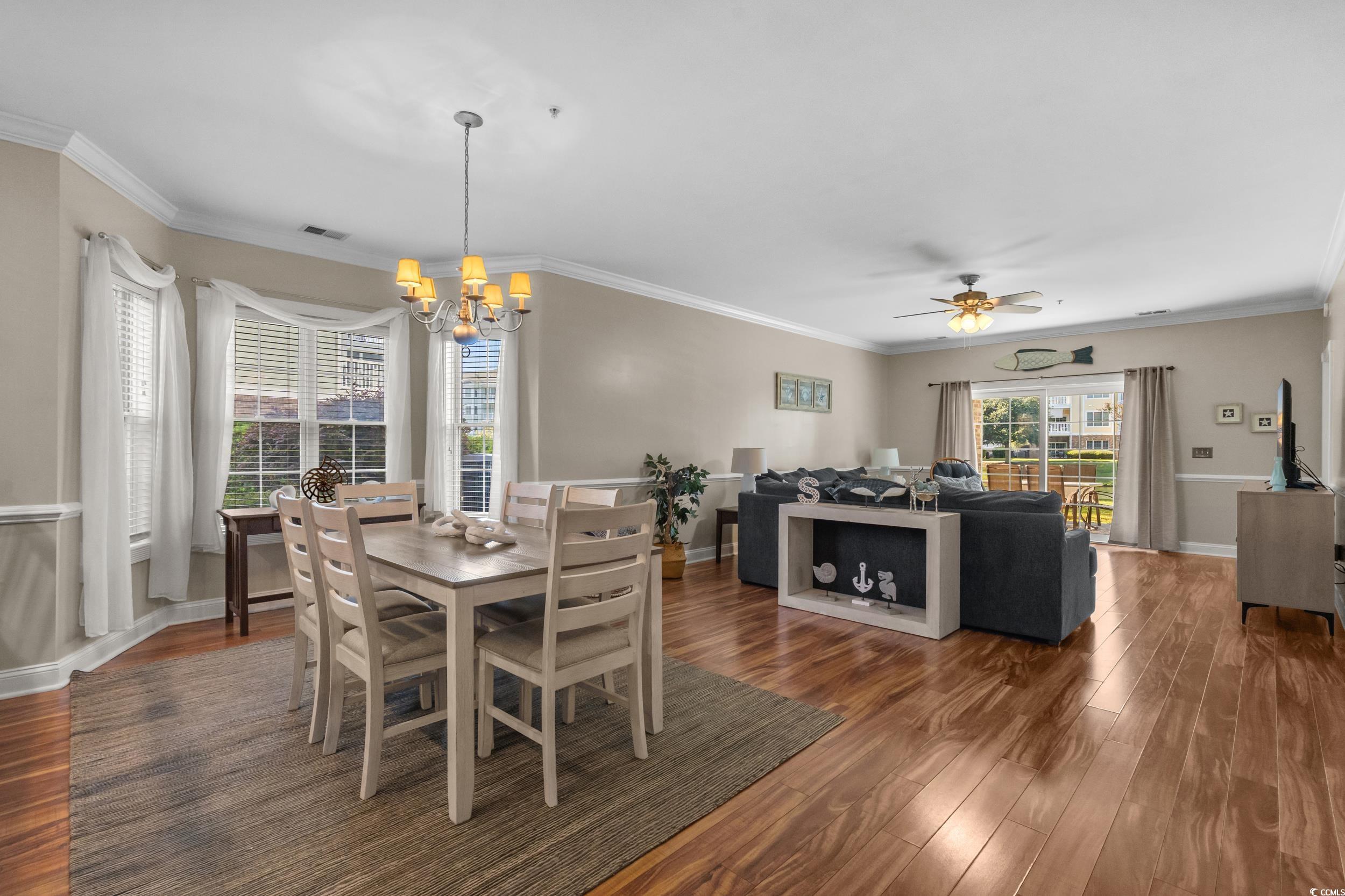 4823 Magnolia Lake Drive, Unit 101 Myrtle Beach, SC 29577 - Photo 6 of 35 Dining area with ornamental molding, dark wood-style flooring, a chandelier, and ceiling fan