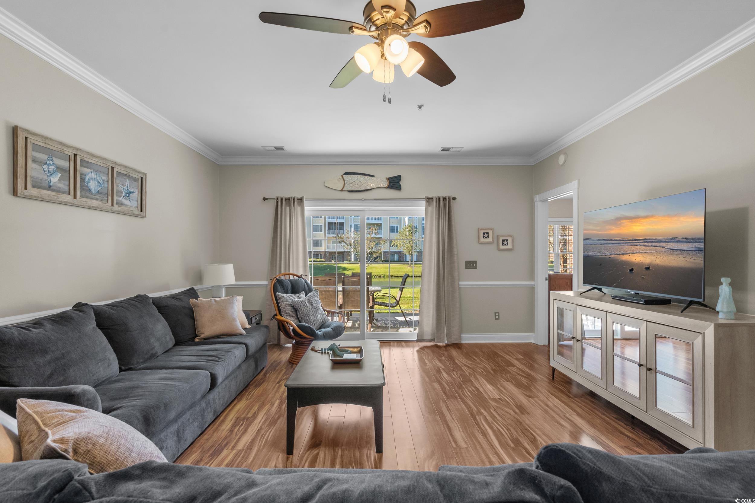 4823 Magnolia Lake Drive, Unit 101 Myrtle Beach, SC 29577 - Photo 8 of 35 Living room featuring crown molding, wood finished floors, and a ceiling fan