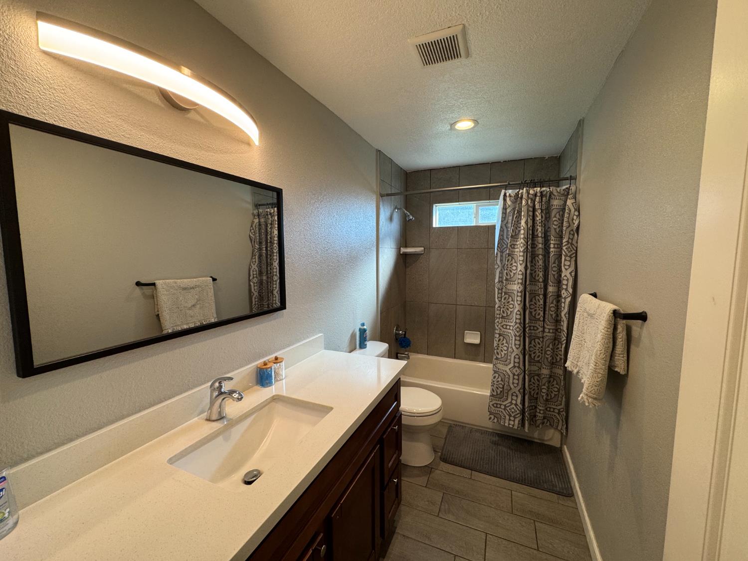 1650 North Olive Avenue Turlock, CA 95382 - Photo 8 of 21 a bathroom with a double vanity sink toilet and mirror