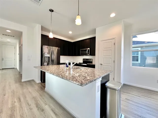 a large kitchen with kitchen island a large counter space a sink appliances and cabinets