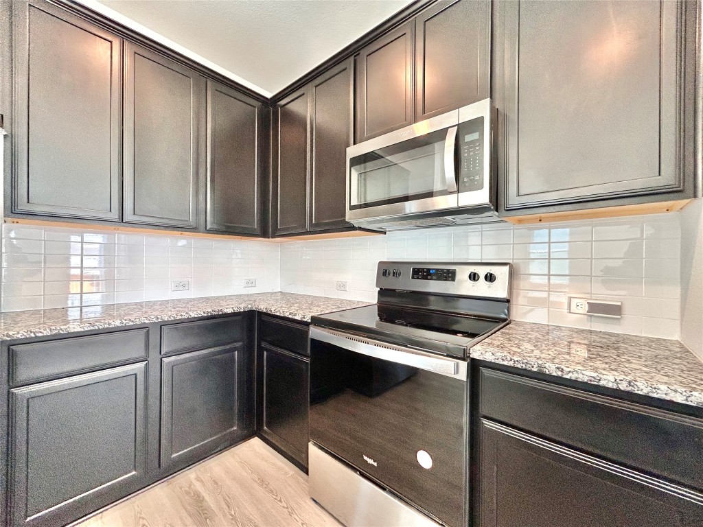 202 Pebblestream Pass Taylor, TX 76574 - Photo 13 of 35 a kitchen with stainless steel appliances granite countertop a sink stove and microwave