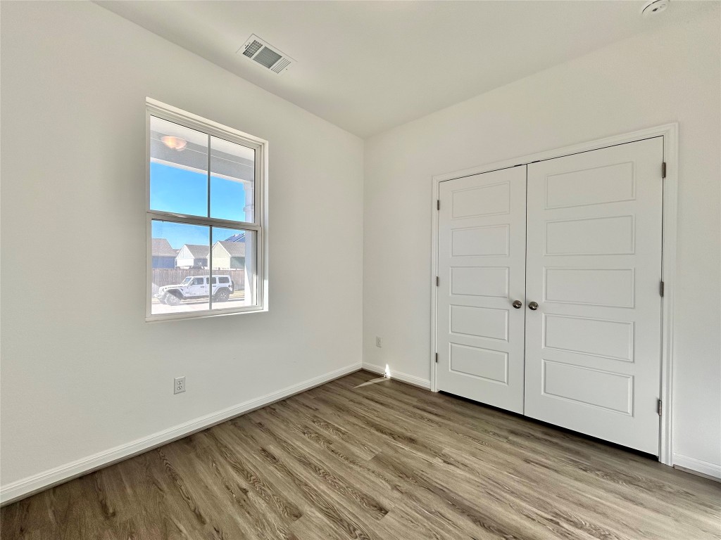 202 Pebblestream Pass Taylor, TX 76574 - Photo 15 of 35 a view of an empty room with wooden floor and a window