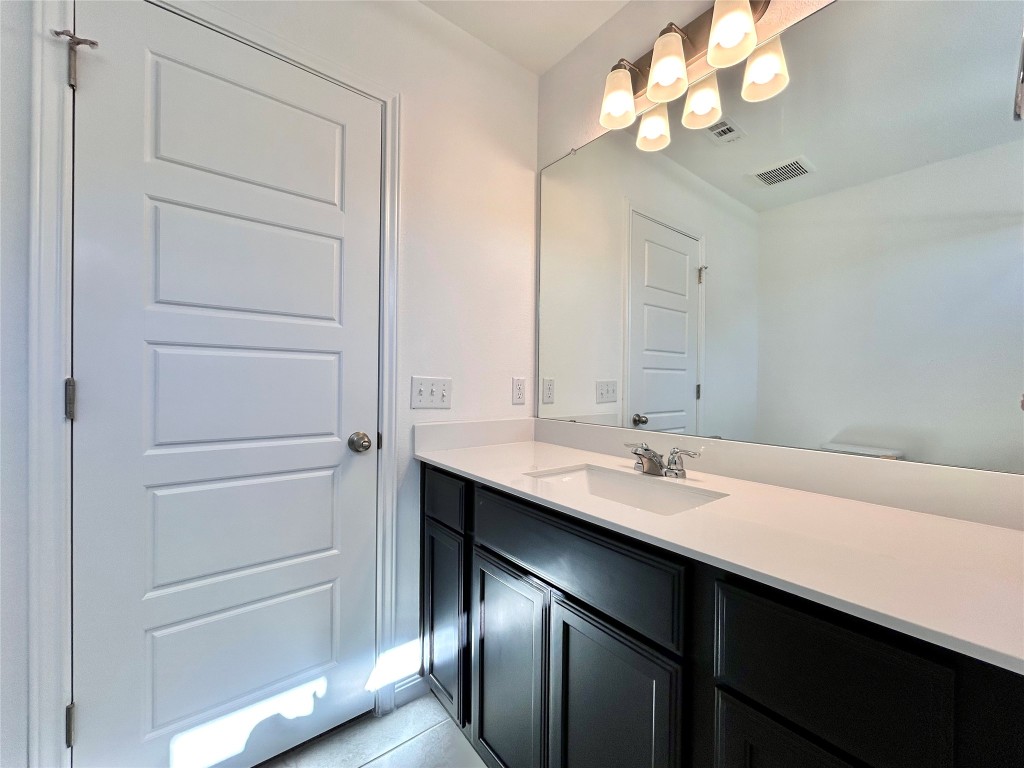 202 Pebblestream Pass Taylor, TX 76574 - Photo 30 of 35 a bathroom with a sink a light fixture and a mirror