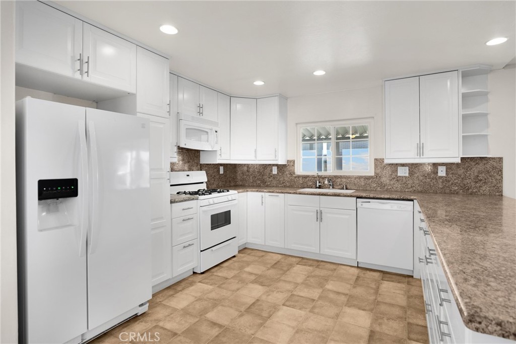 10210 Base Line Road, Unit 291 Rancho Cucamonga, CA 91701 - Photo 15 of 27 a kitchen with white cabinets and white appliances