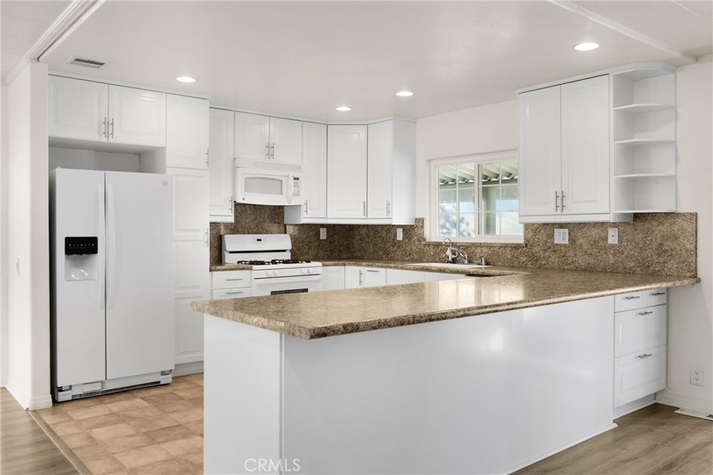 10210 Base Line Road, Unit 291 Rancho Cucamonga, CA 91701 - Photo 16 of 27 a kitchen with stainless steel appliances granite countertop a stove a sink and a refrigerator