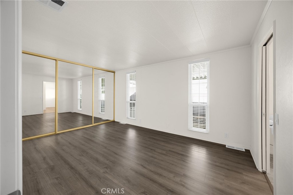 10210 Base Line Road, Unit 291 Rancho Cucamonga, CA 91701 - Photo 17 of 27 an empty room with wooden floor and windows