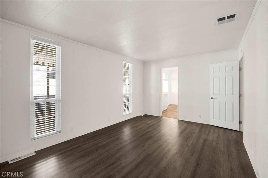10210 Base Line Road, Unit 291 Rancho Cucamonga, CA 91701 - Photo 18 of 27 a view of an empty room with wooden floor and a window