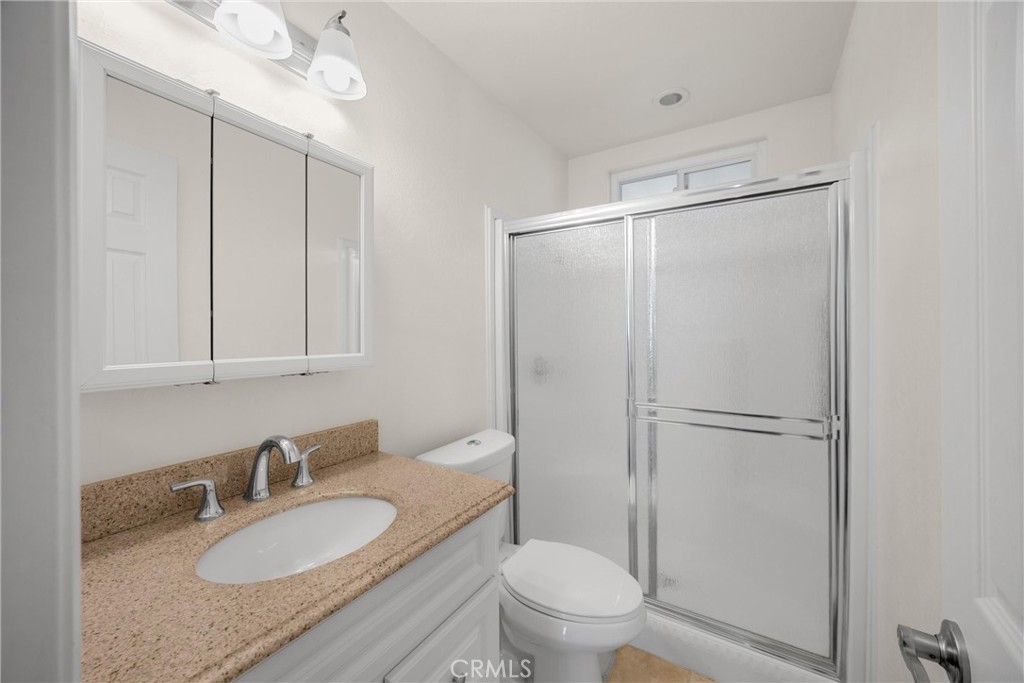 10210 Base Line Road, Unit 291 Rancho Cucamonga, CA 91701 - Photo 21 of 27 a bathroom with a granite countertop sink mirror vanity and toilet