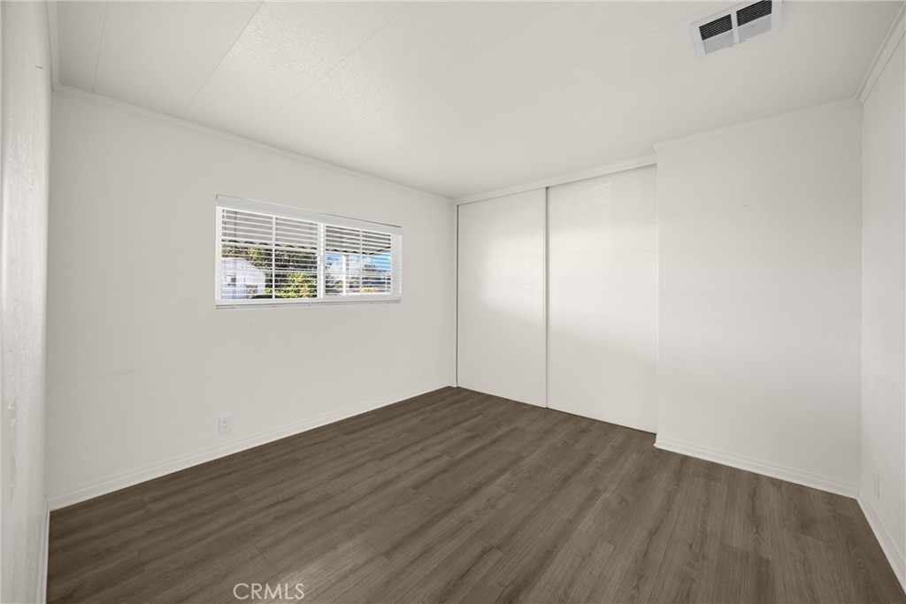 10210 Base Line Road, Unit 291 Rancho Cucamonga, CA 91701 - Photo 22 of 27 an empty room with wooden floor and windows