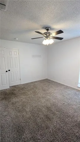 an empty room with fan and entrance