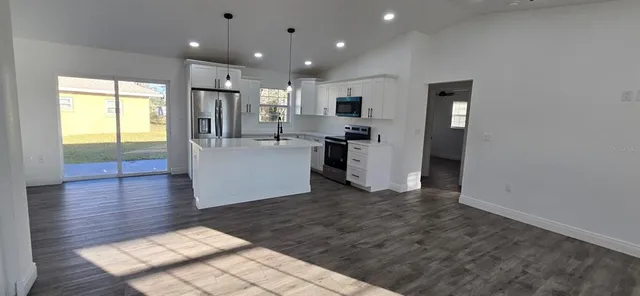 a view of a kitchen with furniture and wooden floor