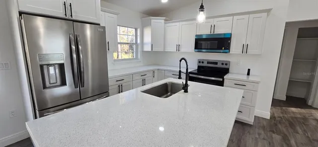 a kitchen with stainless steel appliances a refrigerator stove microwave and sink