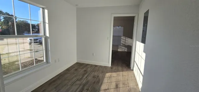 a view of a hallway with wooden floor and a cabinet