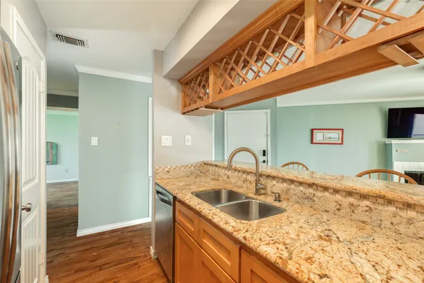 a kitchen with stainless steel appliances granite countertop a sink and dishwasher cabinets with wooden floor