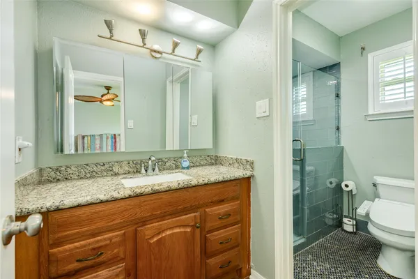 a bathroom with a granite countertop sink toilet and shower