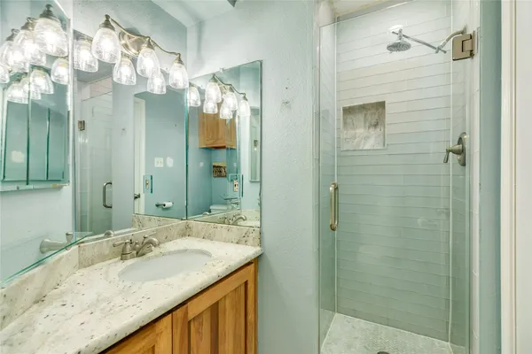 a bathroom with a granite countertop sink and a mirror