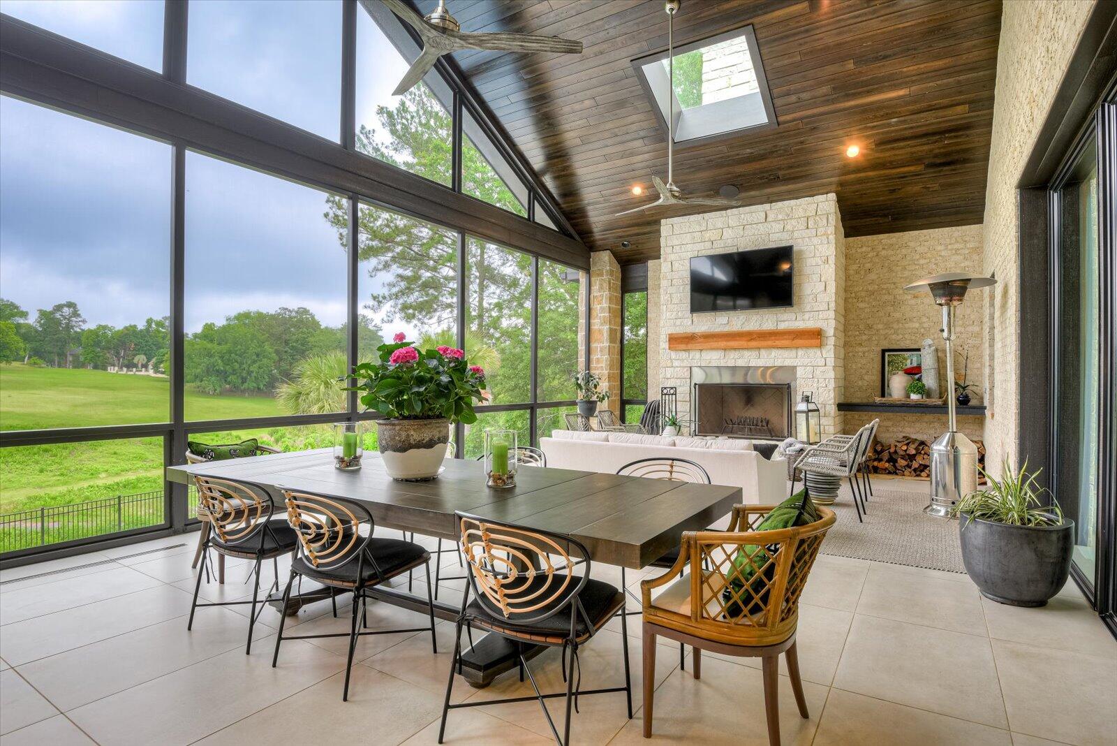 2025 Grace Avenue Evans, GA 30809 - Photo 50 of 67 Upper Porch- Screen/glass enclosure; with large ceramic tile flooring. Wood burning stone fireplace. Tung & groove, stained wood ceiling with skylights and ceiling fans.