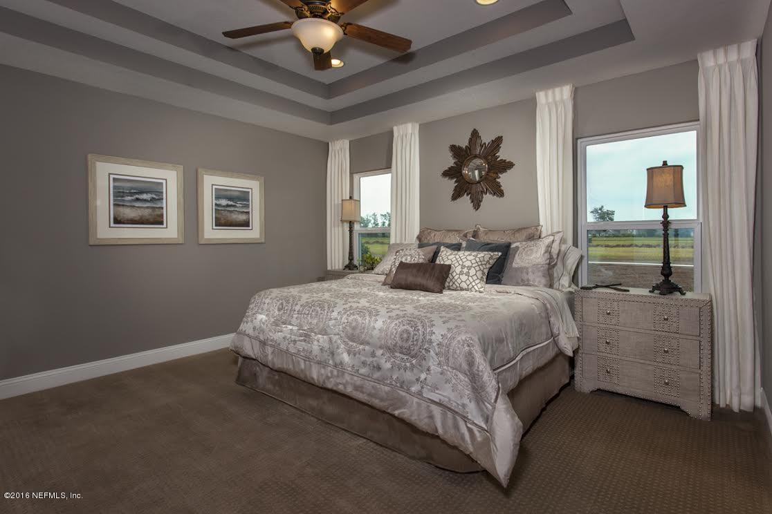 63 Redland Way Jacksonville, FL 32218 - Photo 11 of 14 a bedroom with a large bed and a chandelier fan