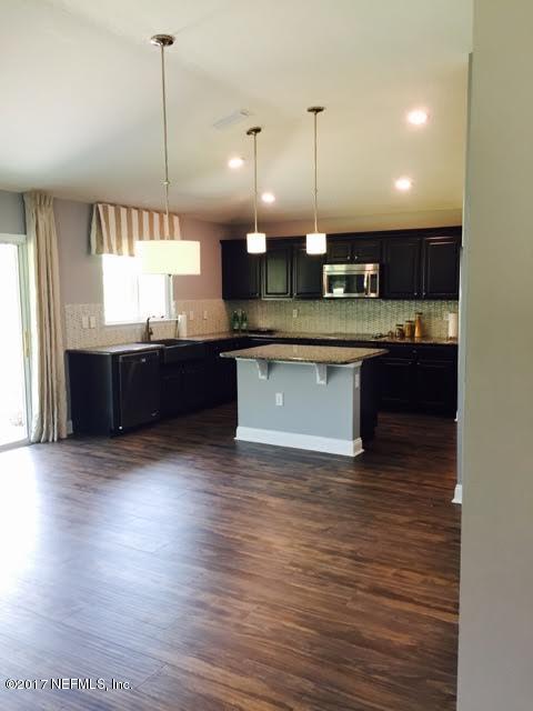 63 Redland Way Jacksonville, FL 32218 - Photo 5 of 14 a large kitchen with stainless steel appliances granite countertop a sink a stove and a wooden floors