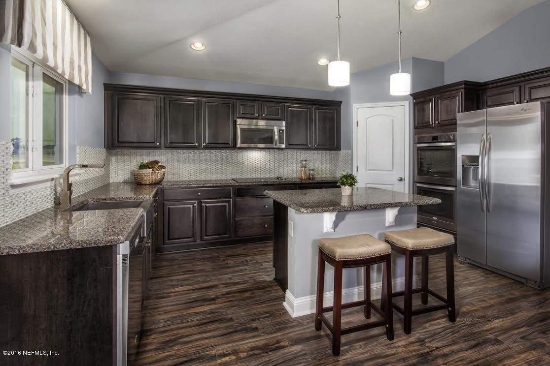63 Redland Way Jacksonville, FL 32218 - Photo 6 of 14 a kitchen with granite countertop kitchen island stainless steel appliances a sink stove and refrigerator