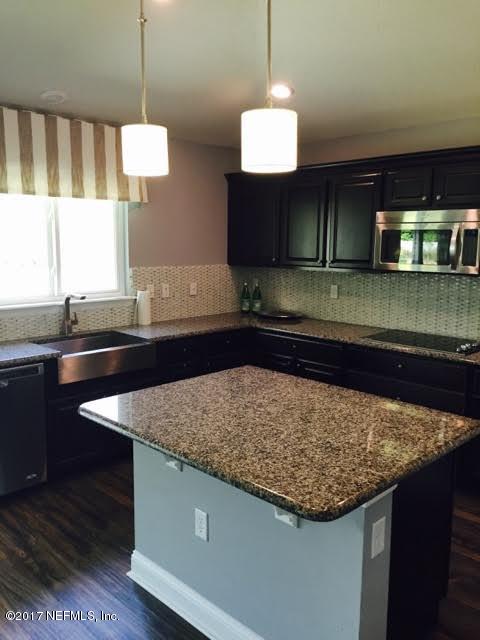 63 Redland Way Jacksonville, FL 32218 - Photo 8 of 14 a kitchen with kitchen island granite countertop wooden cabinets and a sink
