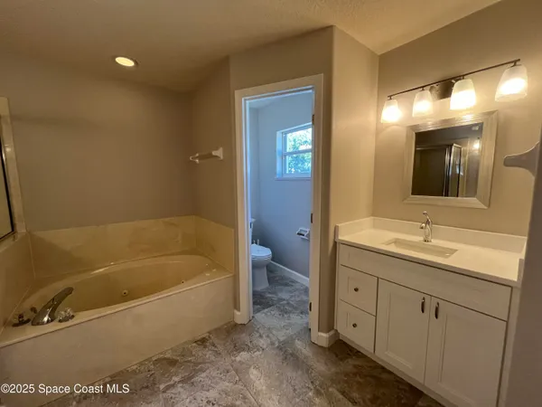 an empty room with closet and a ceiling fan