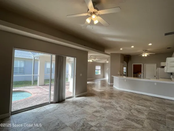 a view of a livingroom with a ceiling fan and window