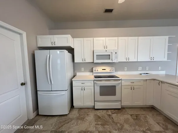 en empty room with windows and ceiling fan