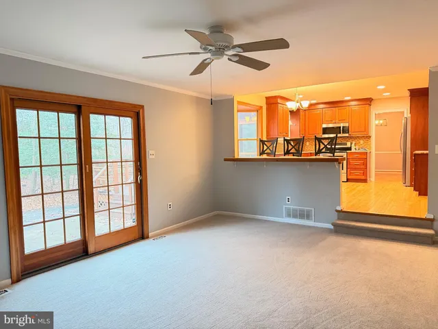 an empty room with windows and ceiling fan